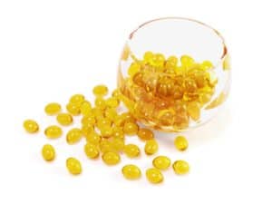 yellow fish oil capsules in glass bowl with clipping path